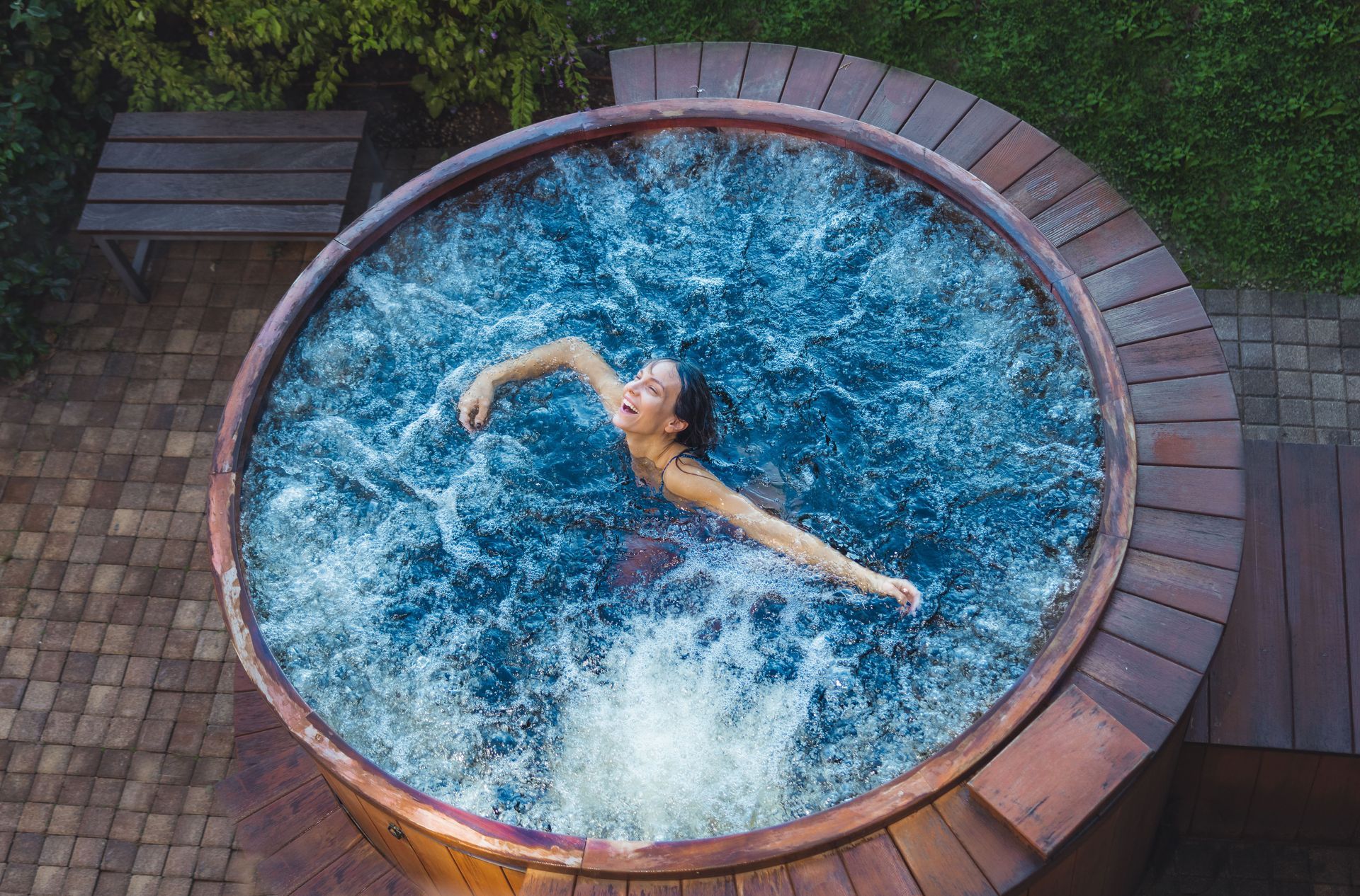 Une femme nage dans un jacuzzi en bois.