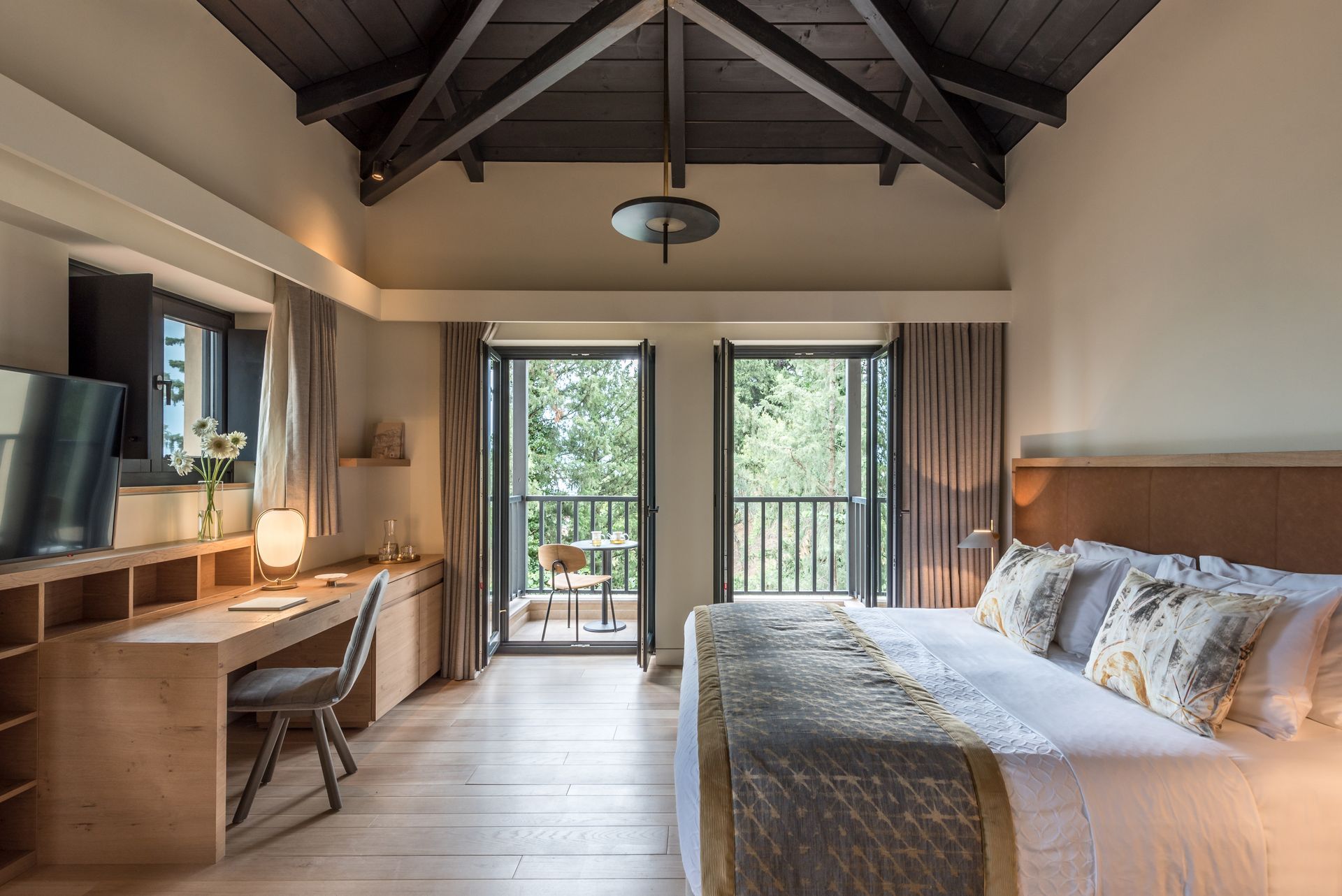 Une chambre d'hôtel avec un grand lit, un bureau, une chaise et un balcon.