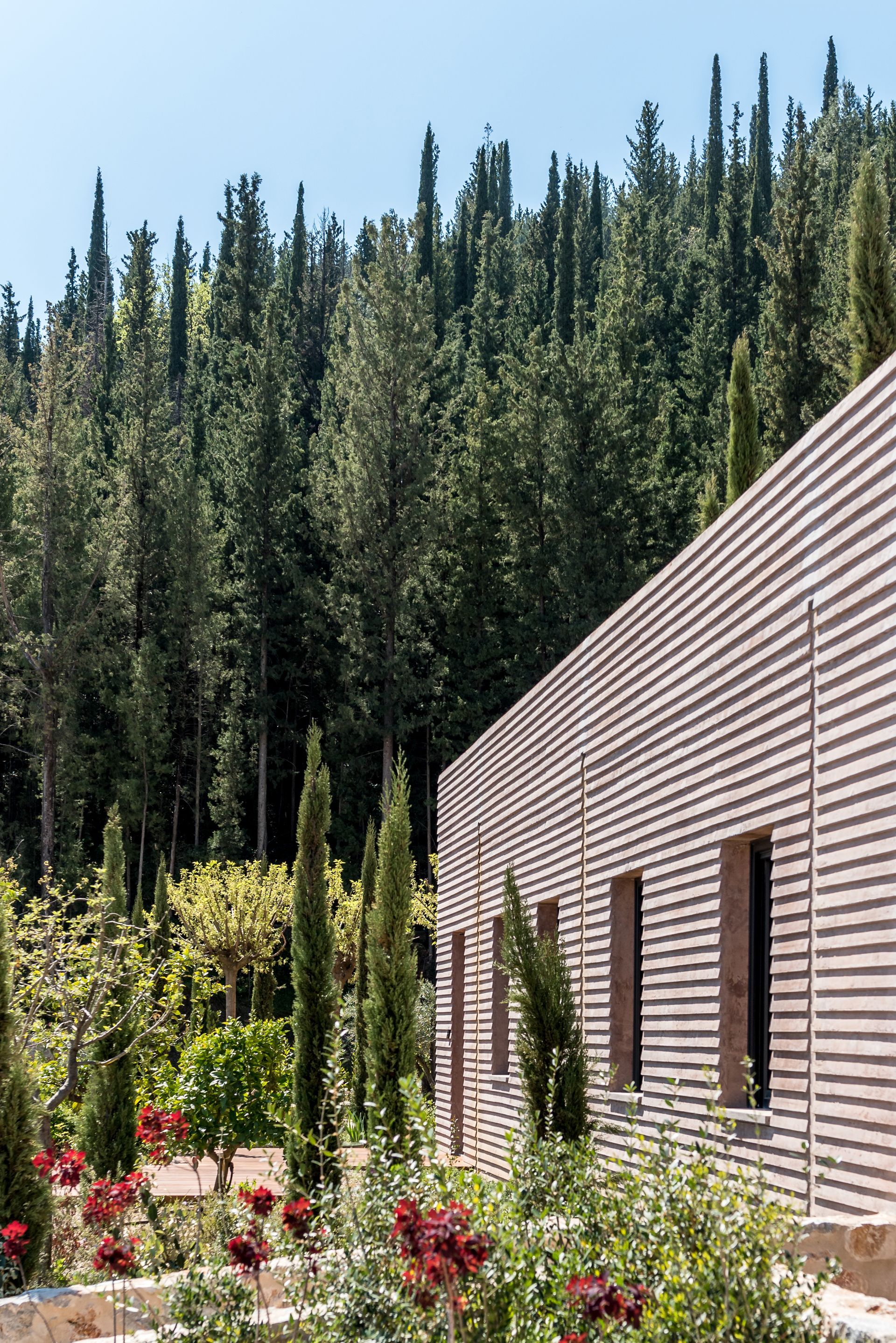 Un bâtiment avec beaucoup de fenêtres se trouve au milieu d'une forêt.