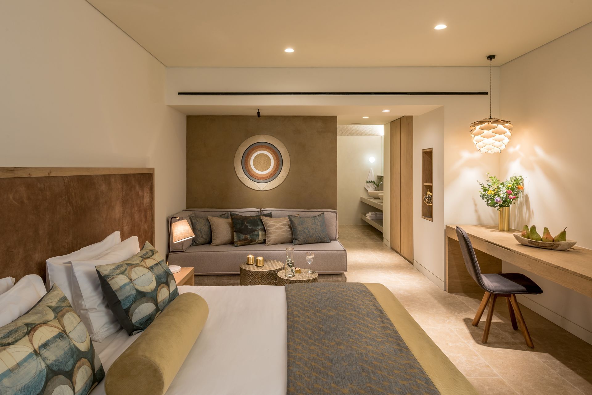 Une chambre d'hôtel avec un lit, un canapé, un bureau et une chaise.