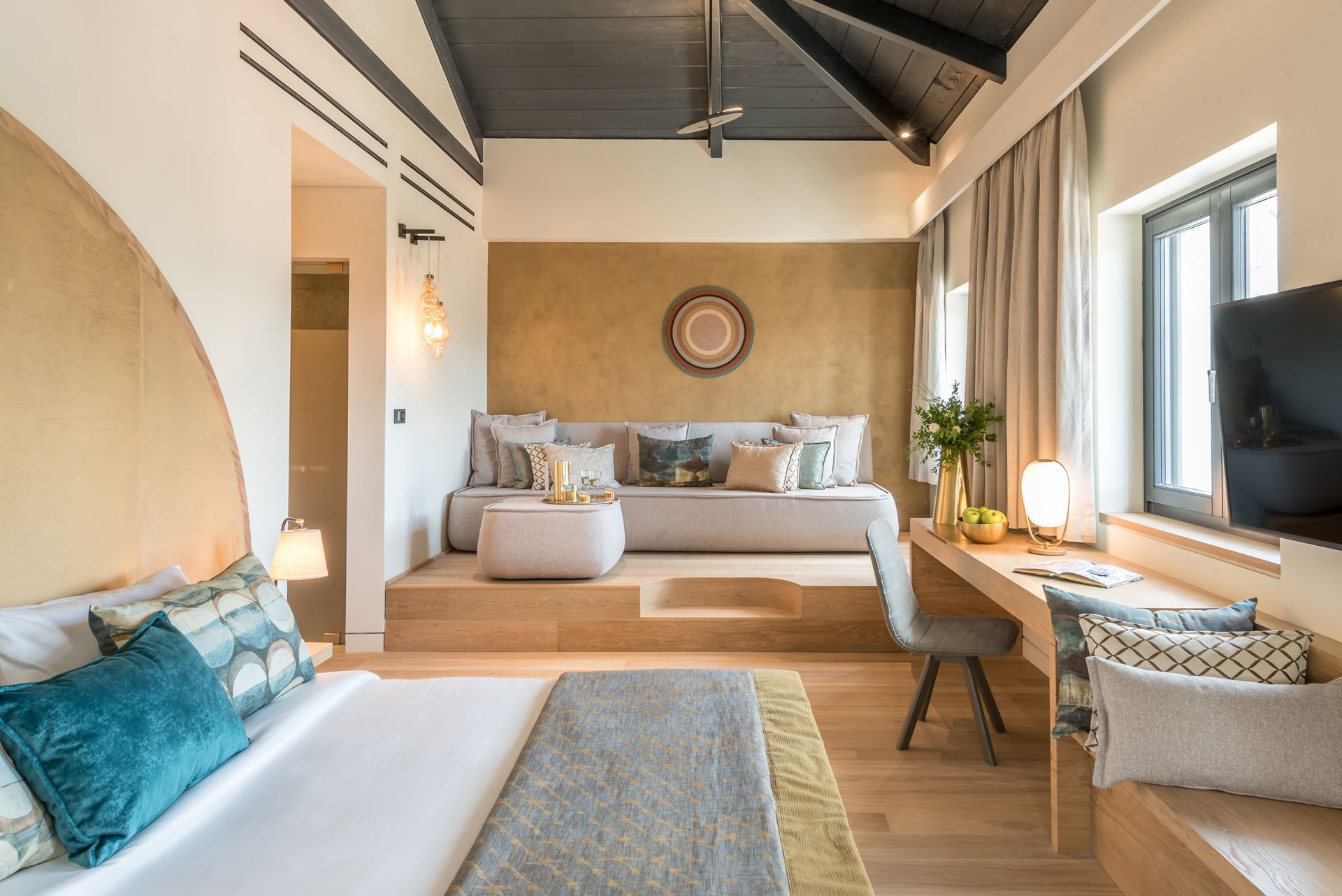 Une chambre d'hôtel avec un lit, un canapé, un bureau et une télévision.