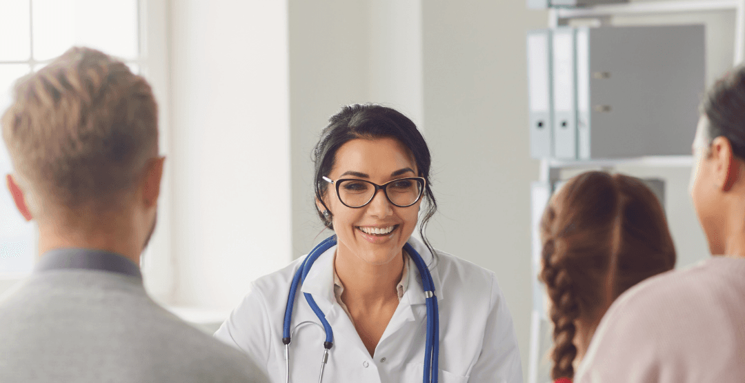 A doctor is talking to a family in a doctor 's office.