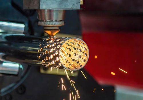 A machine is cutting a metal pipe with sparks coming out of it.