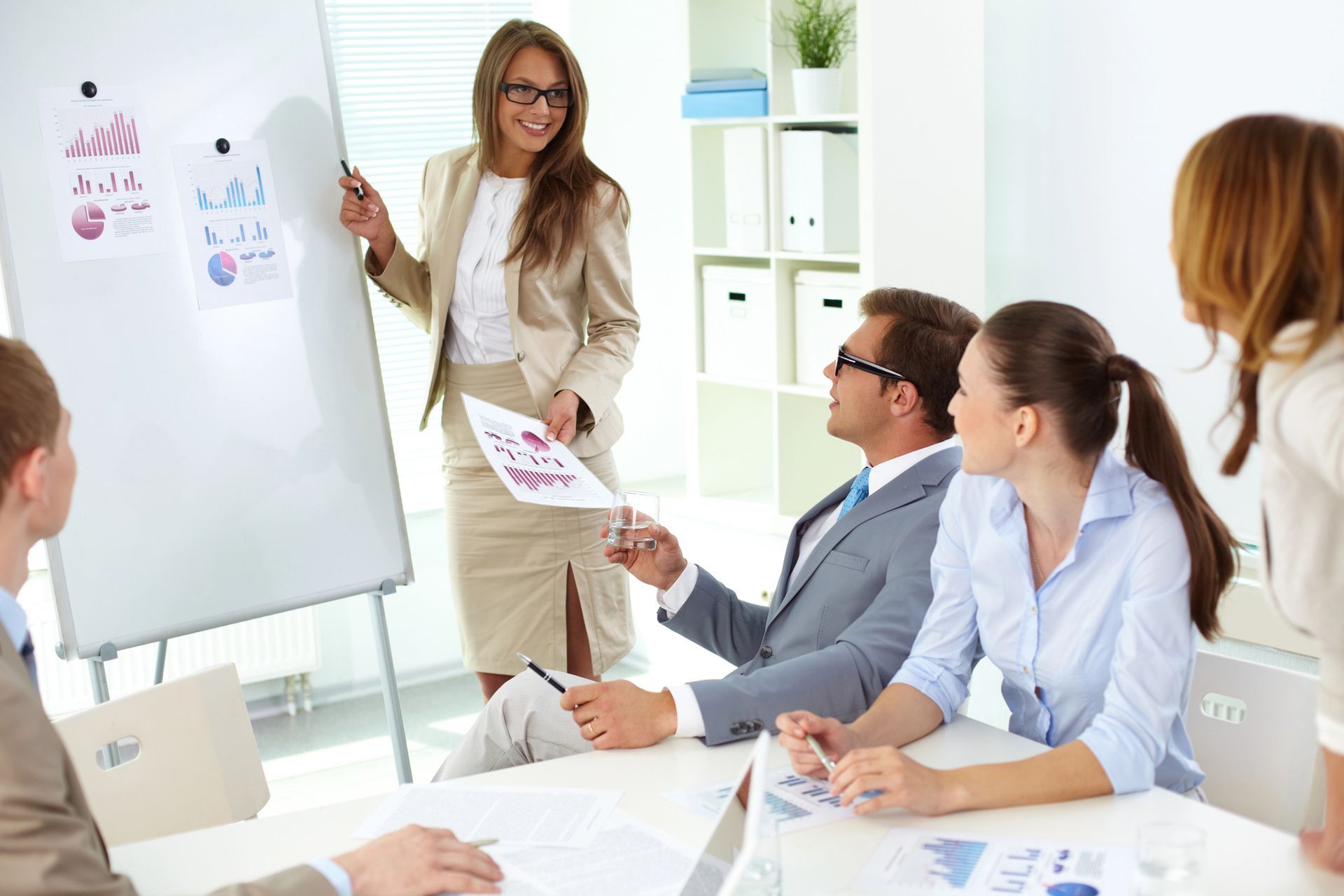 A woman is giving a presentation to a group of business people.