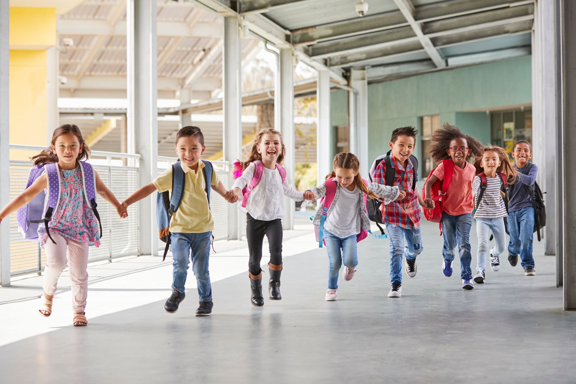 Primary school kids run holding hands
