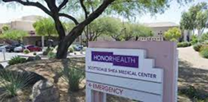 HonorHealth Medical Center sign in front of a desert landscaped parking lot, with trees and buildings behind it