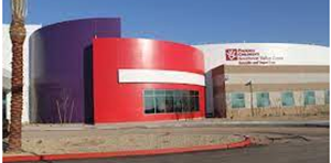 Modern building with a red curved facade and beige exterior under a clear blue sky.