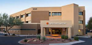 Exterior of a modern tan hospital building with a covered entrance and desert landscaping