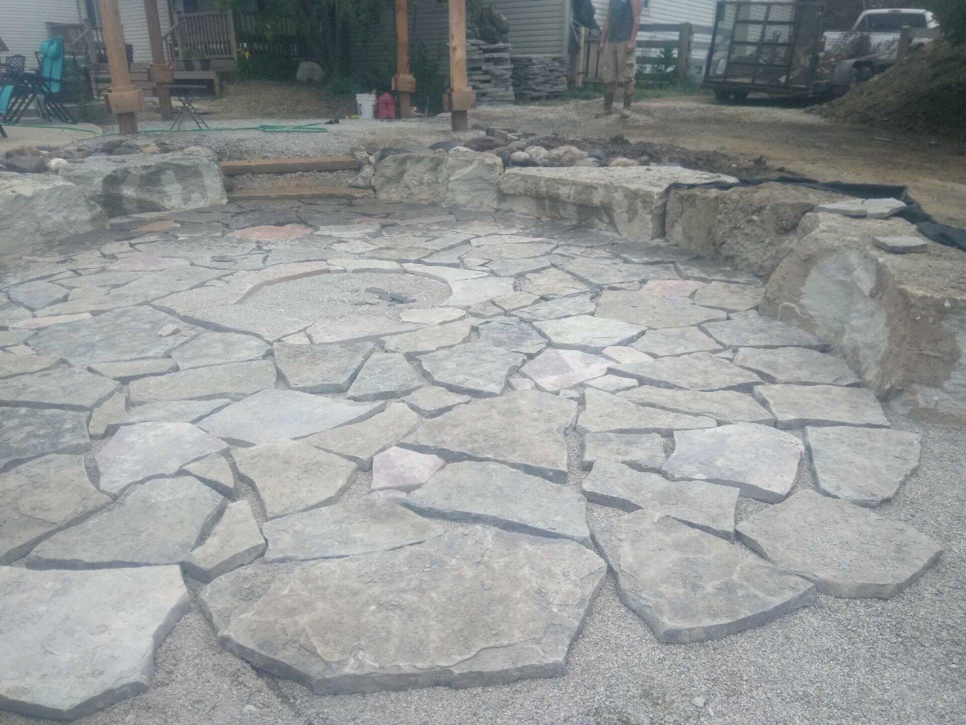 Stone-paved courtyard with a circular stone pattern and raised stone edging in front of a building