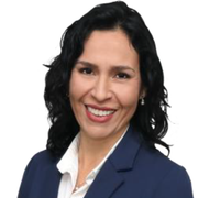 A woman in a blue jacket and white shirt is smiling for the camera.