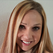 A woman with blonde and brown hair is smiling for the camera