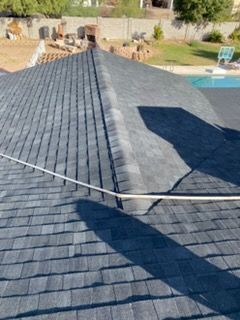 Dome skylights on a brown shingle roof, sun shining.