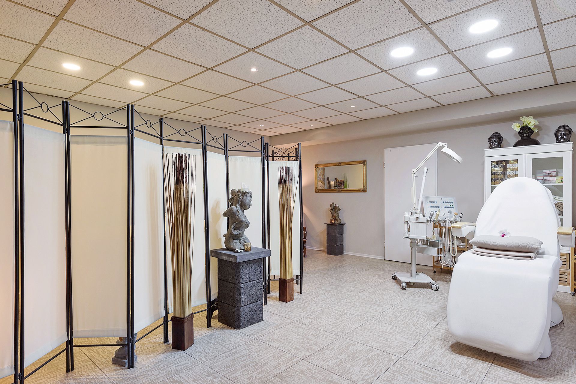 Ein Zimmer mit einem weißen Stuhl und einem Spiegel an der Wand