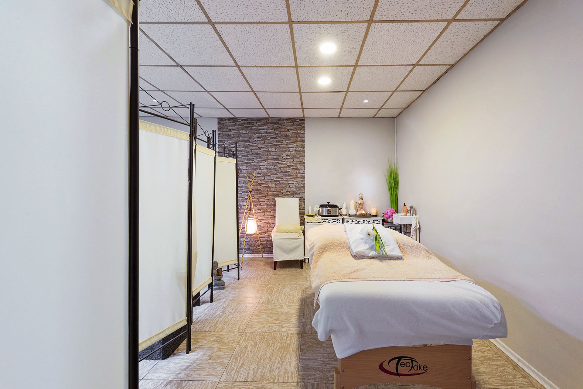 In der Mitte des Raumes steht ein Massagetisch.