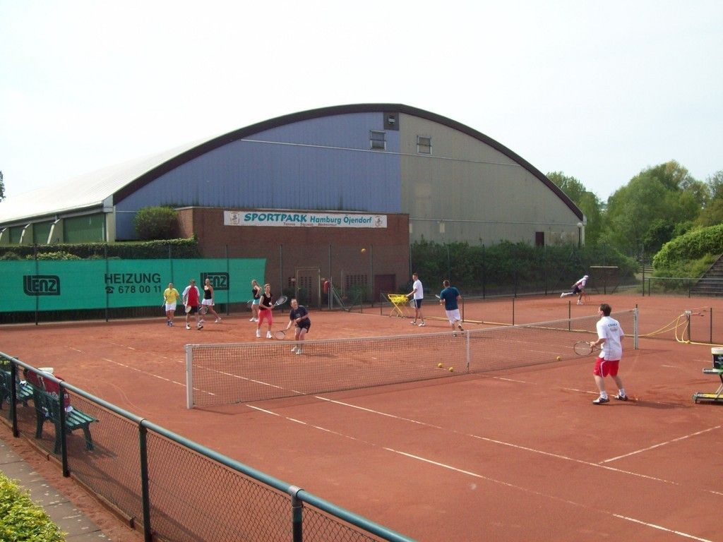 Eine Gruppe von Menschen spielt Tennis auf einem Tennisplatz