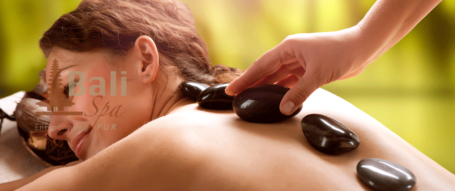 Eine Frau bekommt in einem Spa eine Hot-Stone-Massage.
