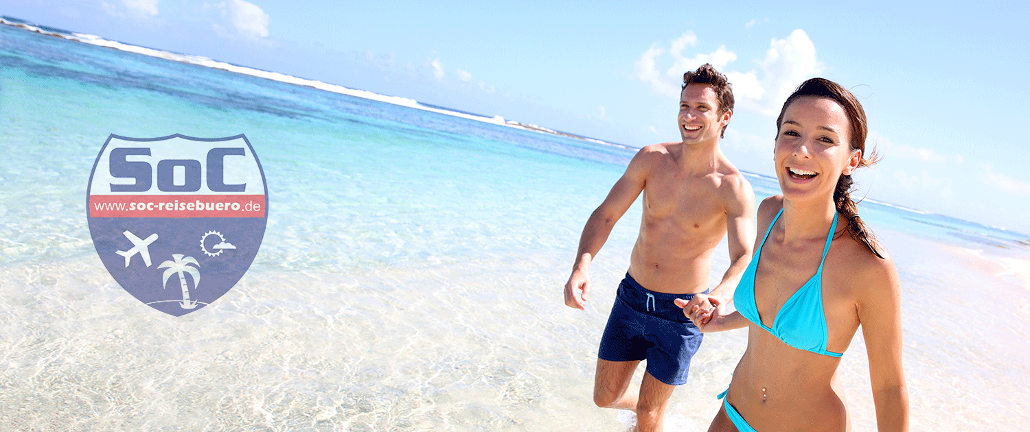Ein Mann und eine Frau in Bikinis laufen an einem Strand.