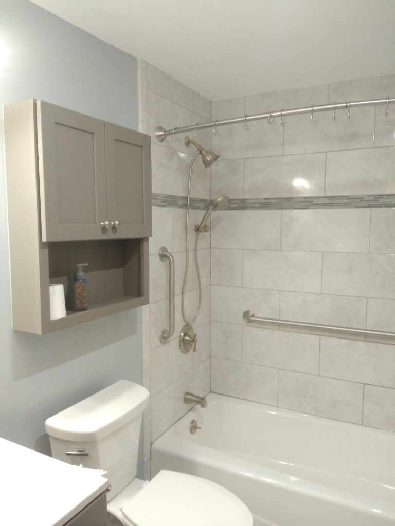 Small bathroom with shower-tub, beige tile, wall cabinet, and toilet.