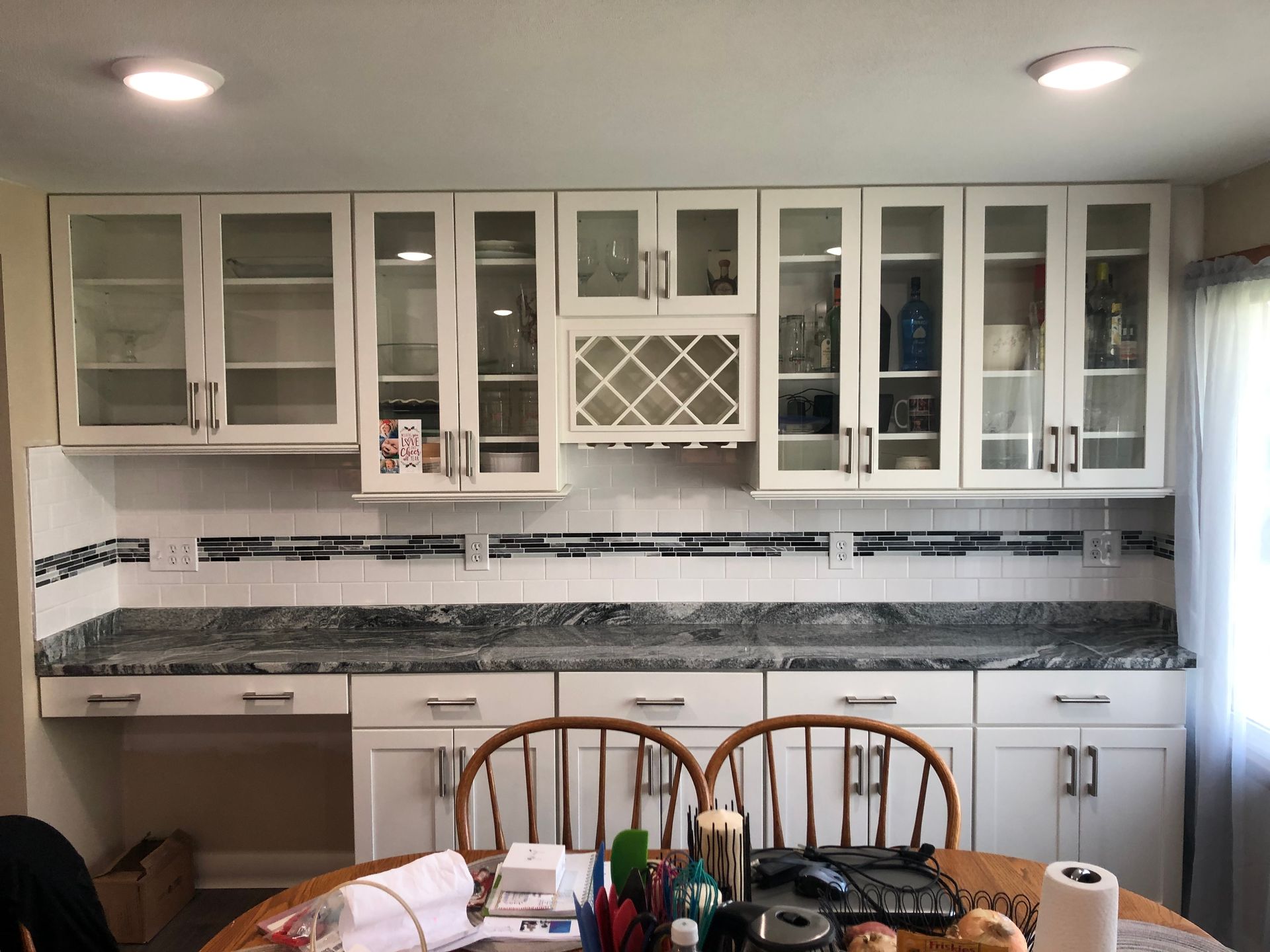 Kitchen with white cabinets, granite countertops, and a dining table in the foreground