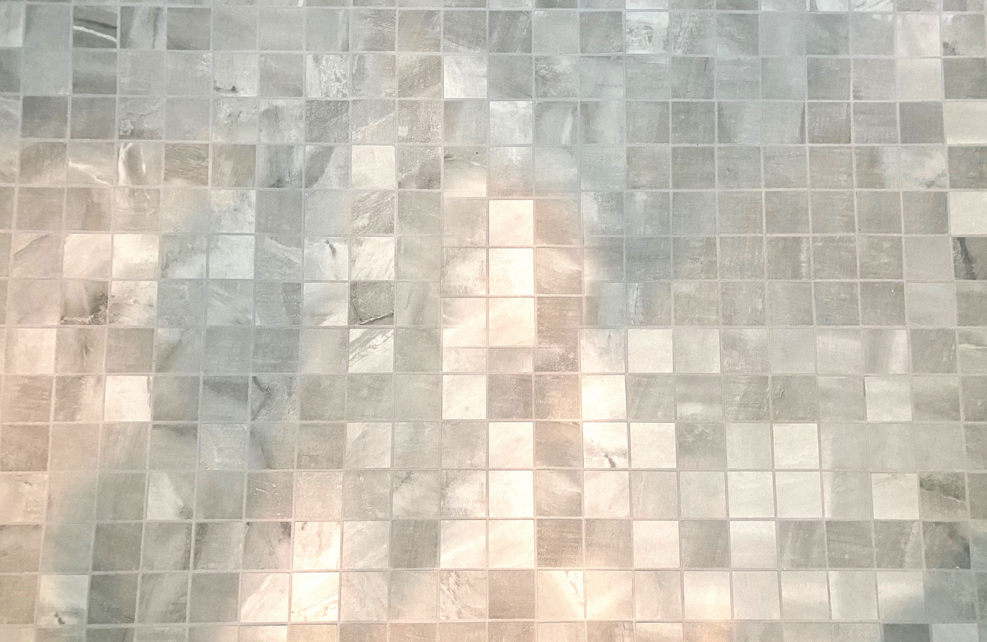 Abstract mosaic of pale gray and beige squares with a faint central human figure