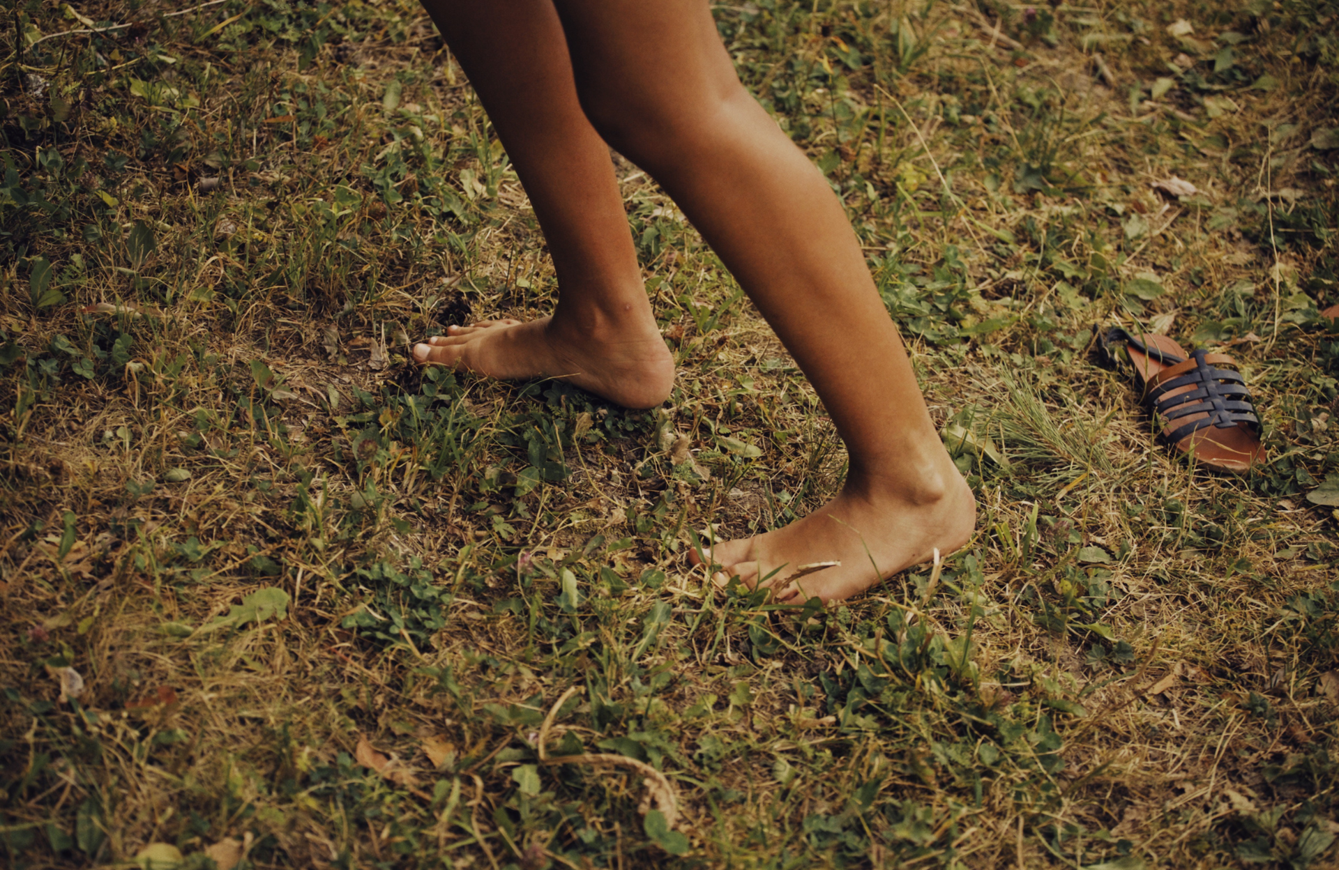 Bare feet walking on dry grass and dirt outdoors