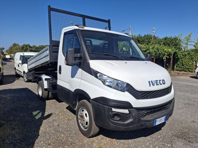 Camion pianale Iveco bianco parcheggiato all'aperto su un piazzale ghiaioso sotto un cielo azzurro.