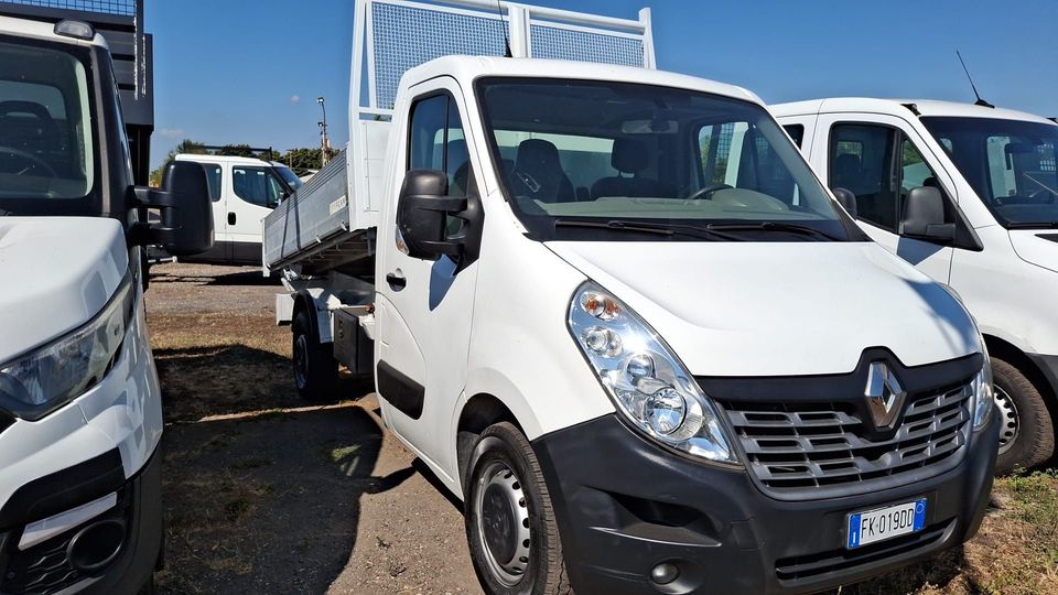 In un parcheggio erano parcheggiati dei furgoni Renault bianchi, con un furgone anteriore posizionato al centro tra gli altri veicoli commerciali.