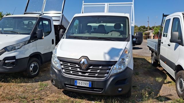 Furgoni bianchi parcheggiati fianco a fianco in un parcheggio all'aperto soleggiato.