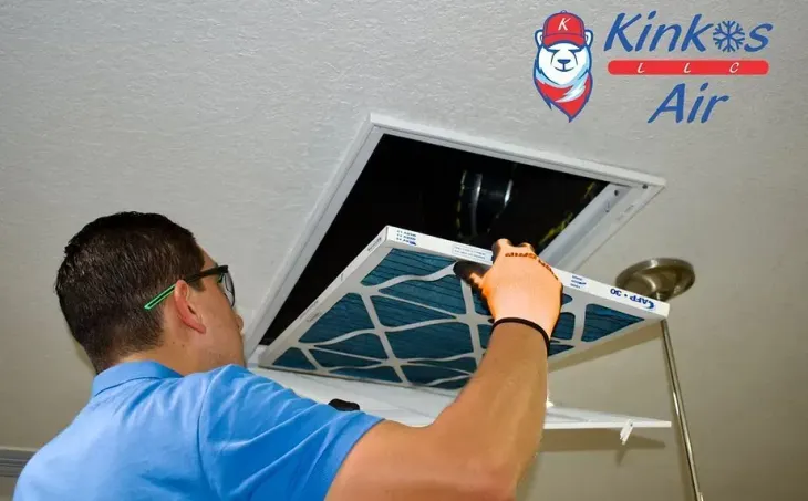 Technician in blue shirt replacing an attic air vent cover with a screwdriver Technician in blue shirt replacing an attic air vent cover with a screwdriver