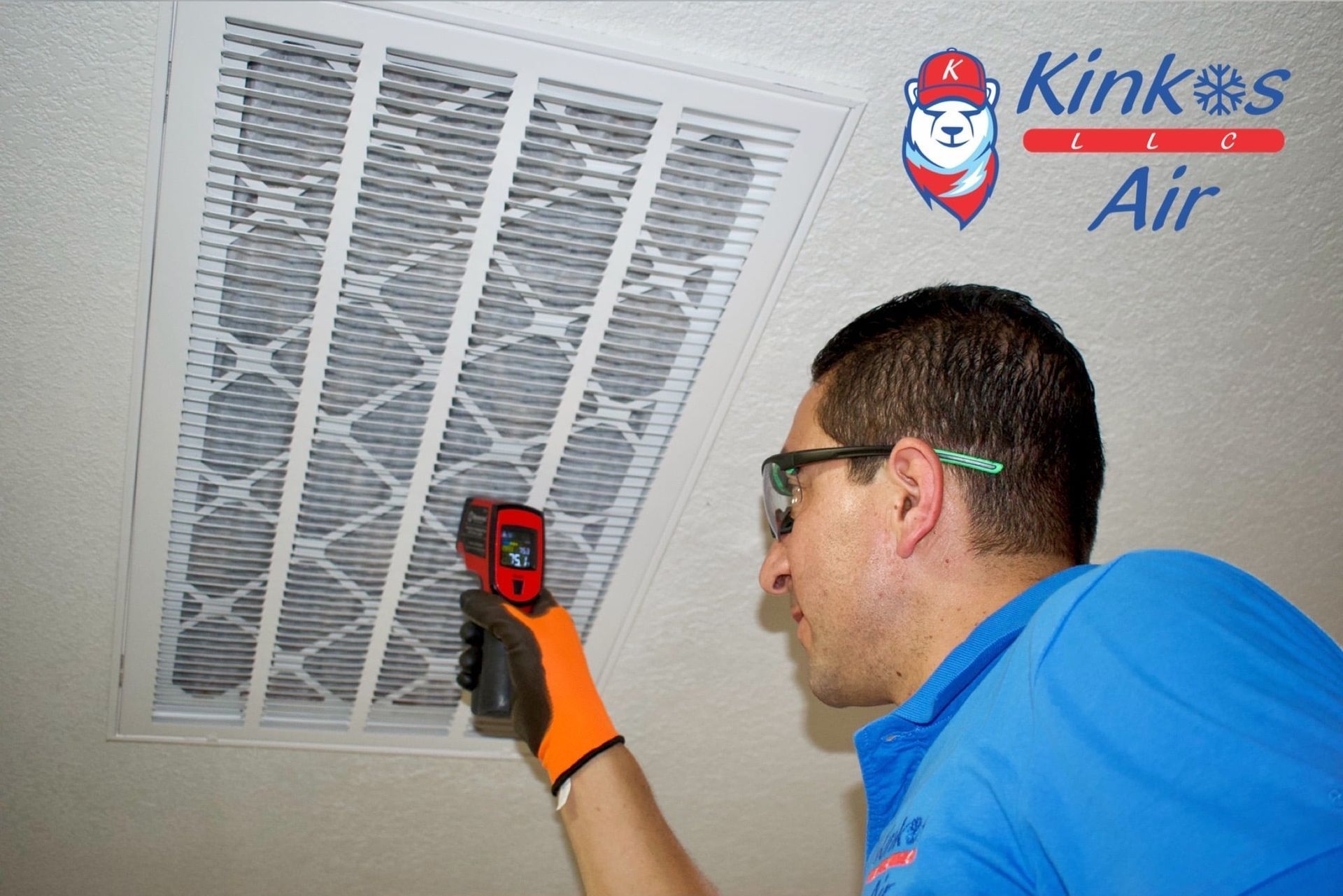 Technician in blue shirt uses a thermal camera to inspect a ceiling vent for Kinkos Air.