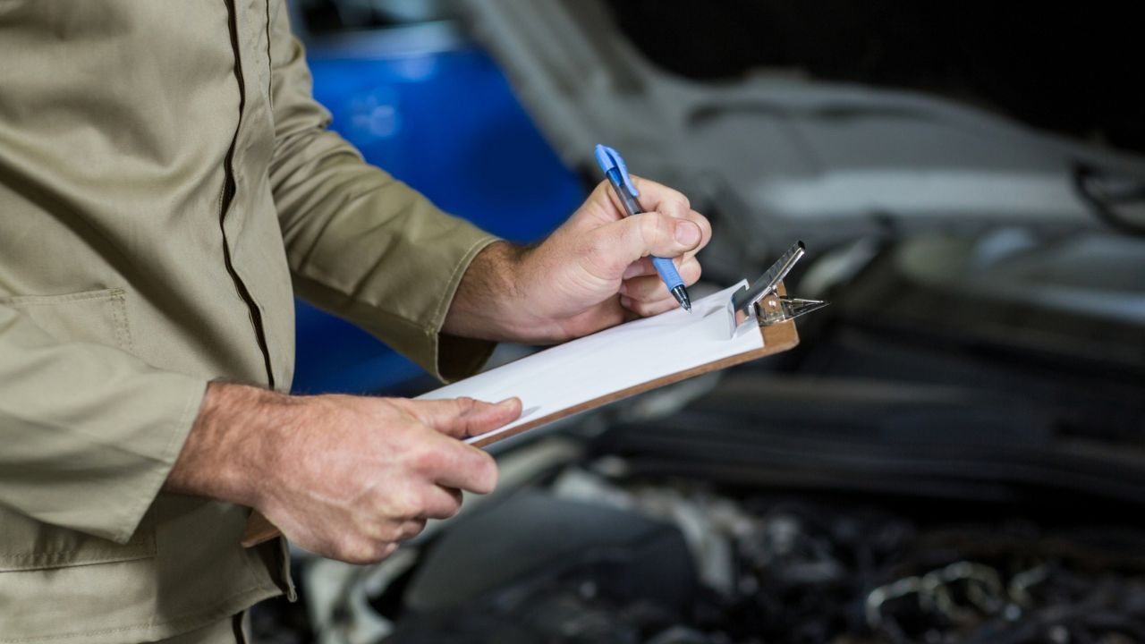 Automotive expert reviewing a car service checklist before inspection