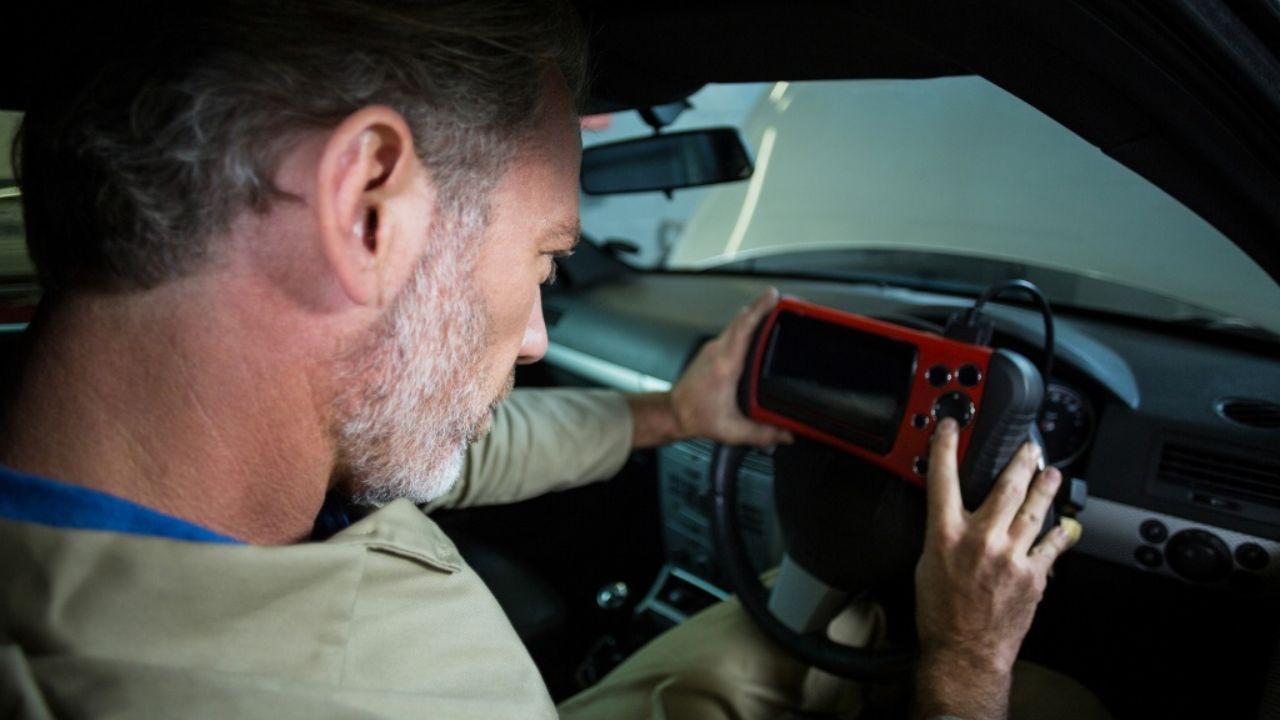 Driver adjusting the air vent and climate control dials on a car center console while driving
