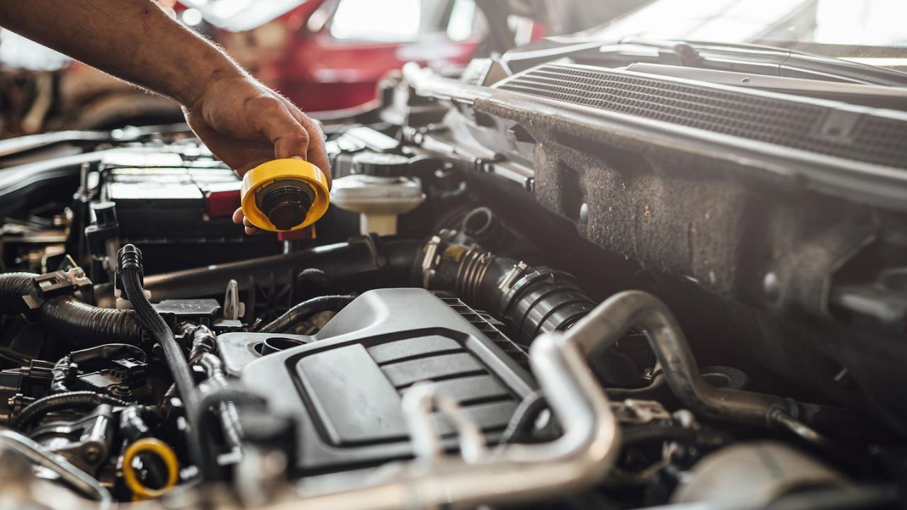 Mechanic inspecting engine with oil cap removed