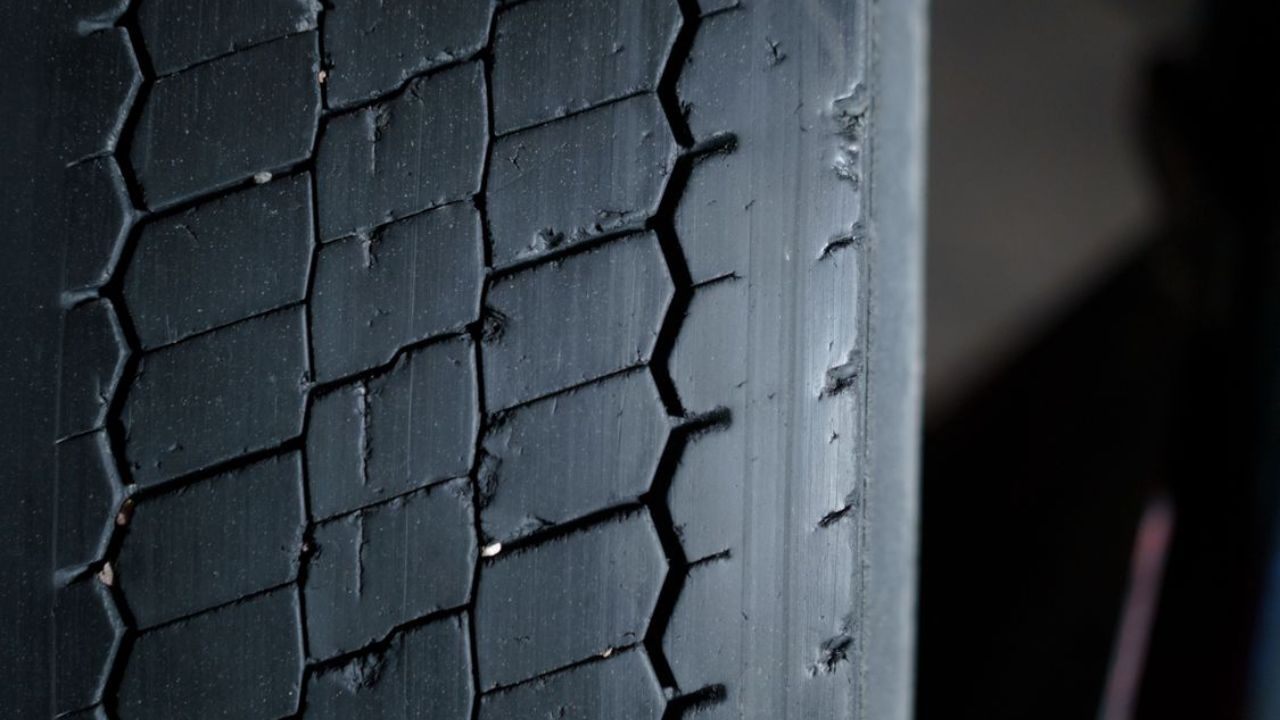 Close-up of an unevenly worn tire displaying irregular tread wear patterns