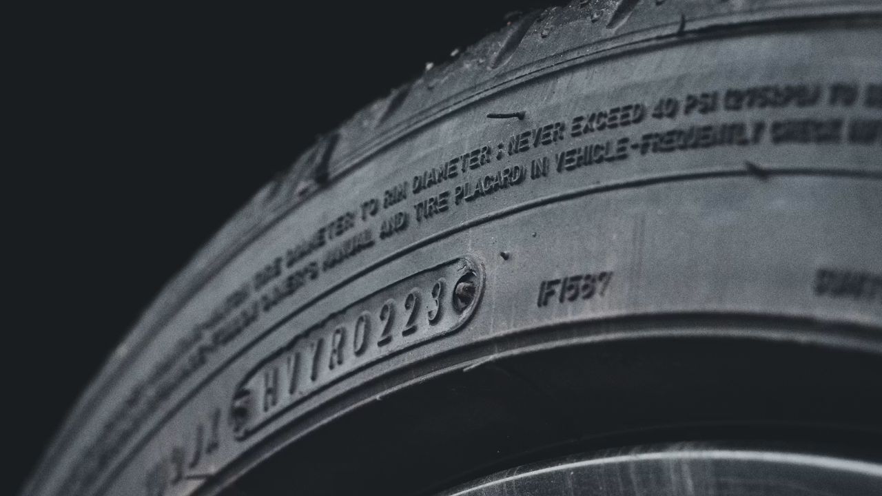 Tire sidewall displaying the DOT manufacturing code and tire identification number