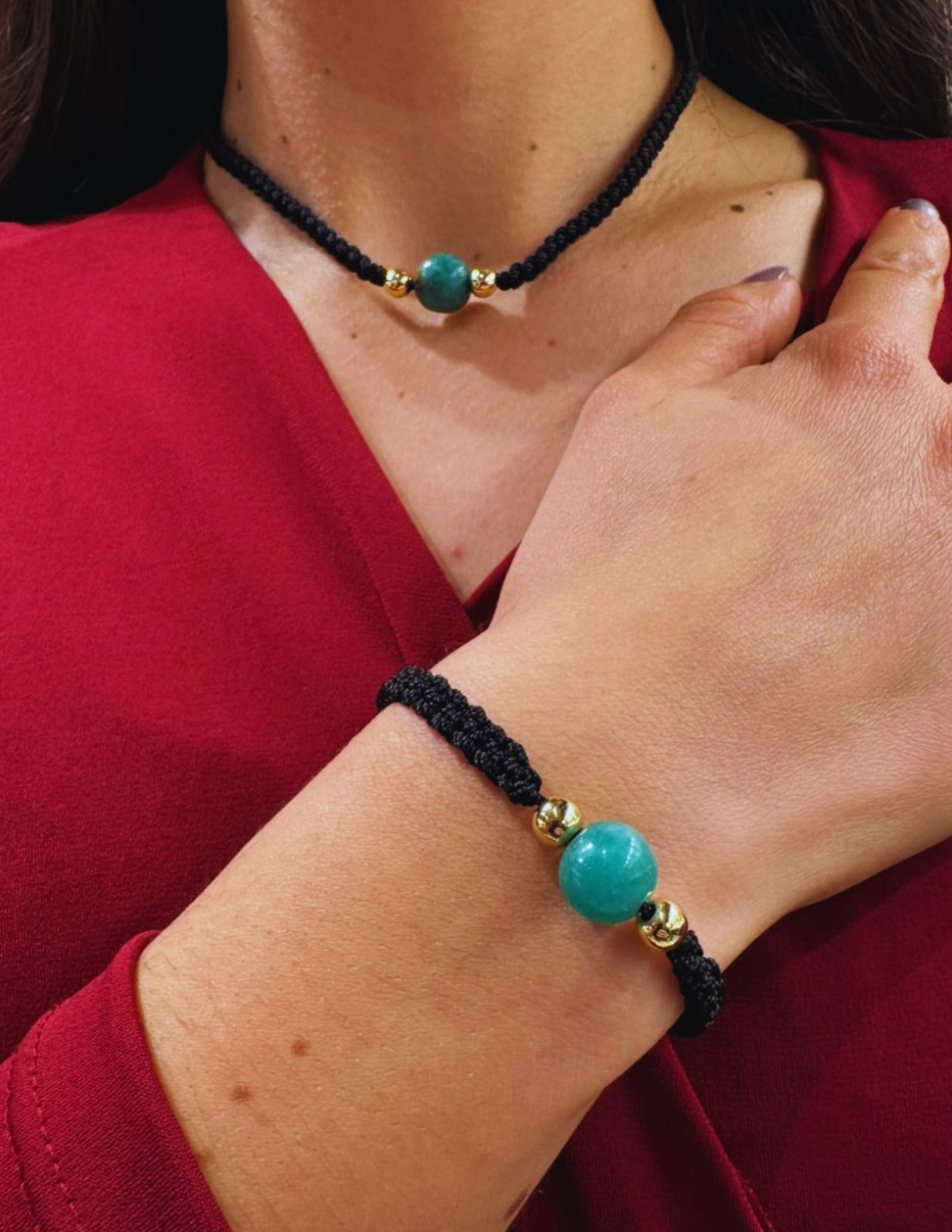 Collar negro de cuentas y pulsera a juego con cuentas turquesas, sobre una blusa roja