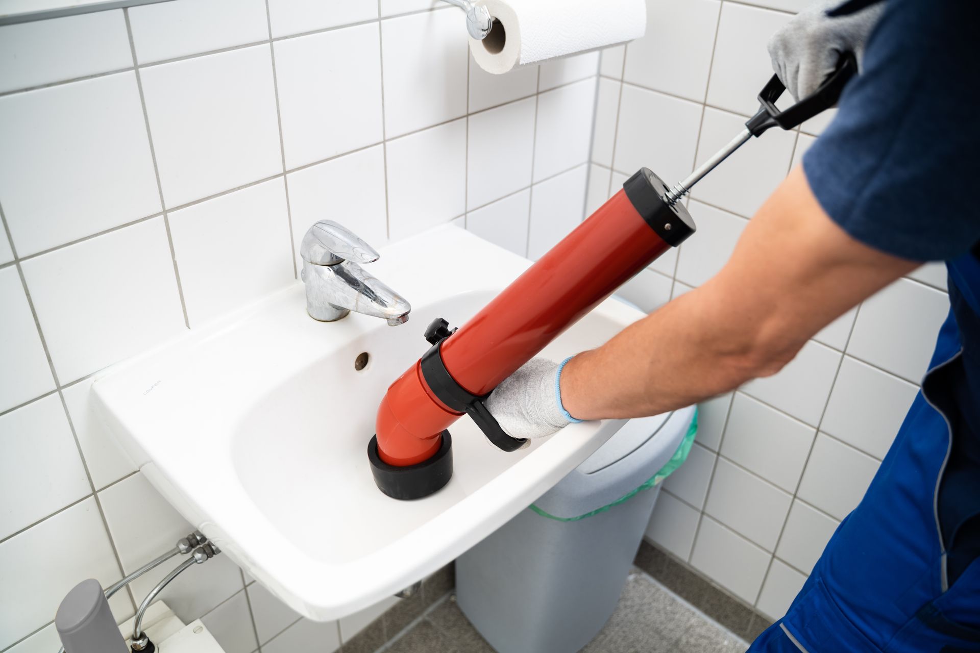 Plumber Cleaning Drain And Bathroom Sink Using Pump.