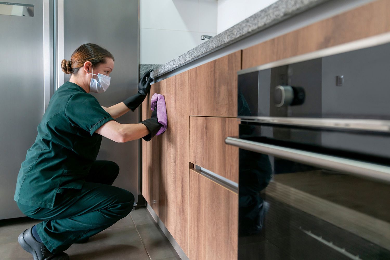 Cleaning cart in a brightly lit hallway with closed doors. Cleaning cart in a brightly lit hallway with closed doors.