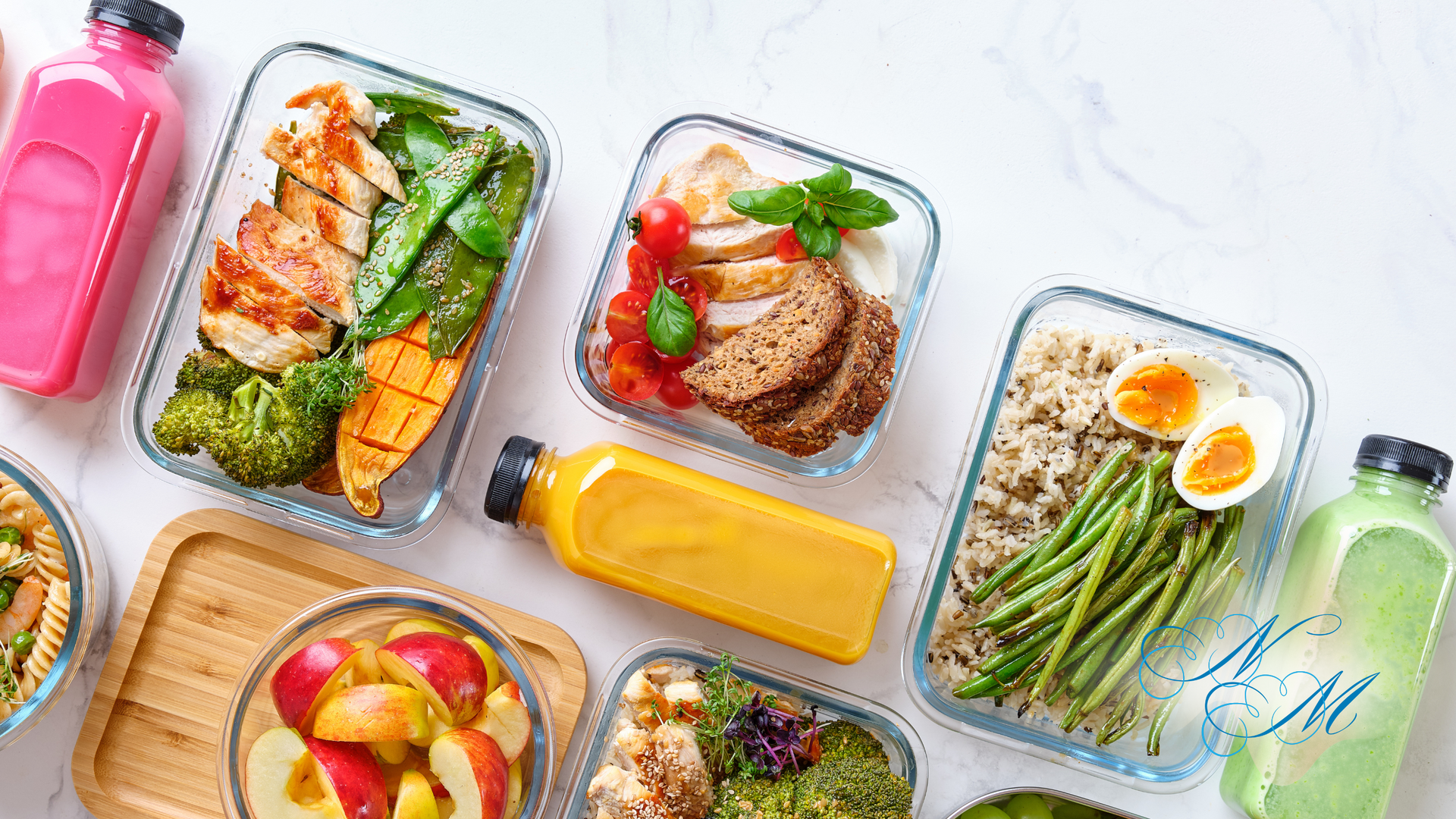 Overhead view of healthy meal prep with grilled chicken, vegetables, fruit, and juice in glass containers.