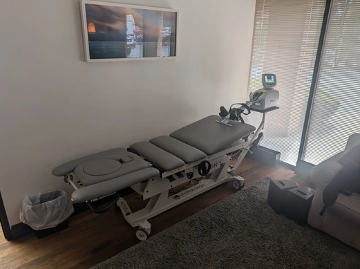 A massage table is sitting in a room next to a window.