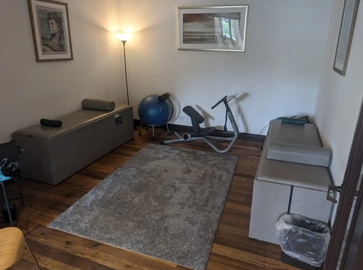 A room with a couch and a exercise bike in it