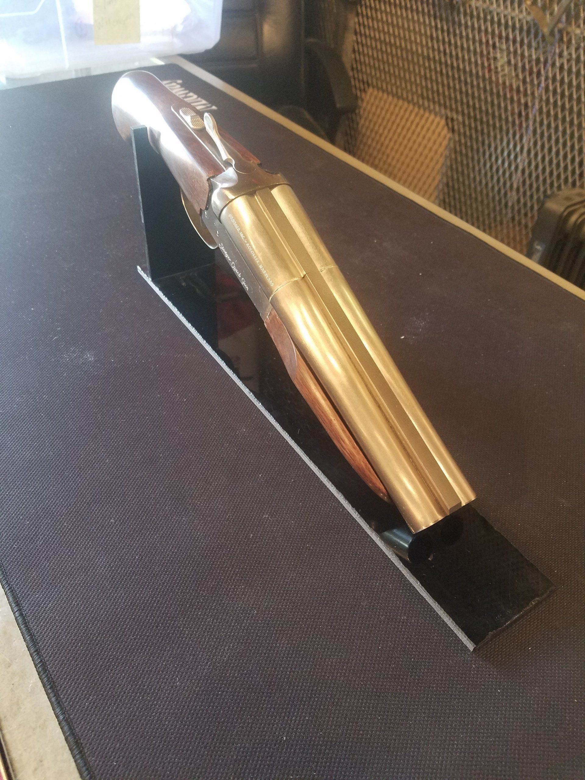 A pen-shaped trophy on a black stand, set against a dark tablecloth.