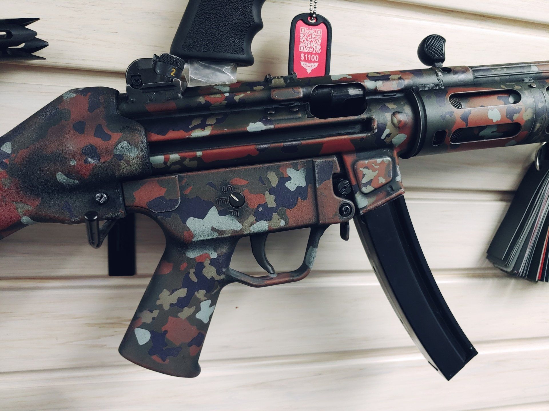 Camouflage painted submachine gun with a black magazine.