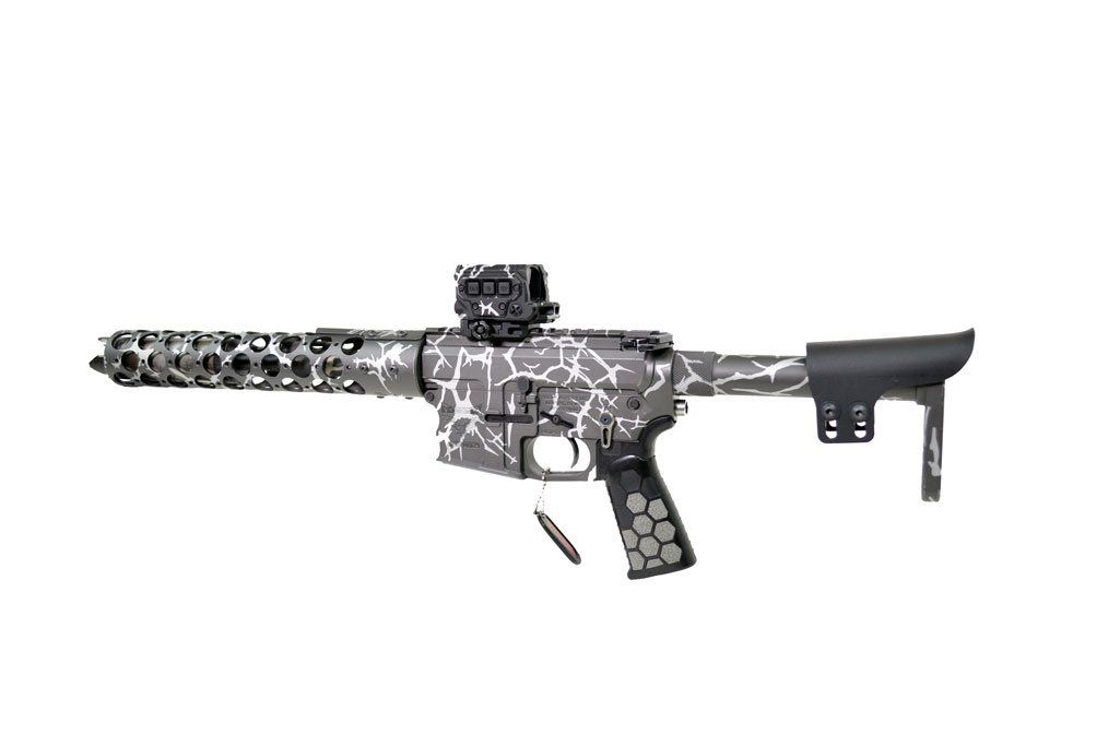 Assault rifle with a cracked pattern, red dot sight, and a vented handguard.