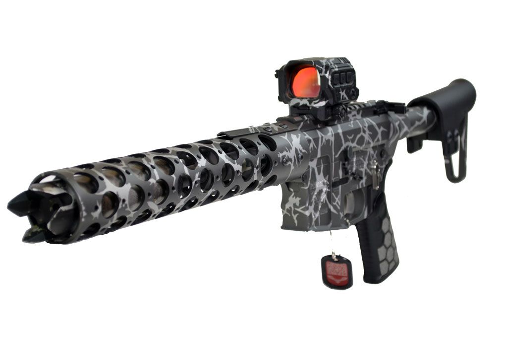 Black and gray rifle with a large vented barrel, red dot sight, and a black stock.