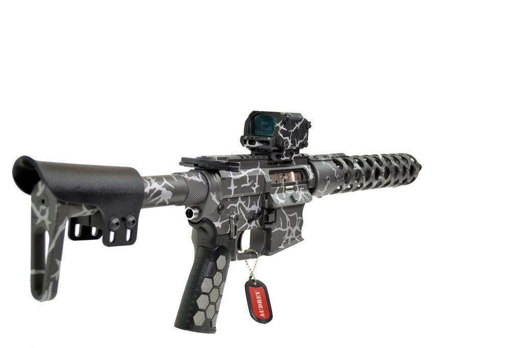 Gray and black rifle with a red sight and a red tag hanging.