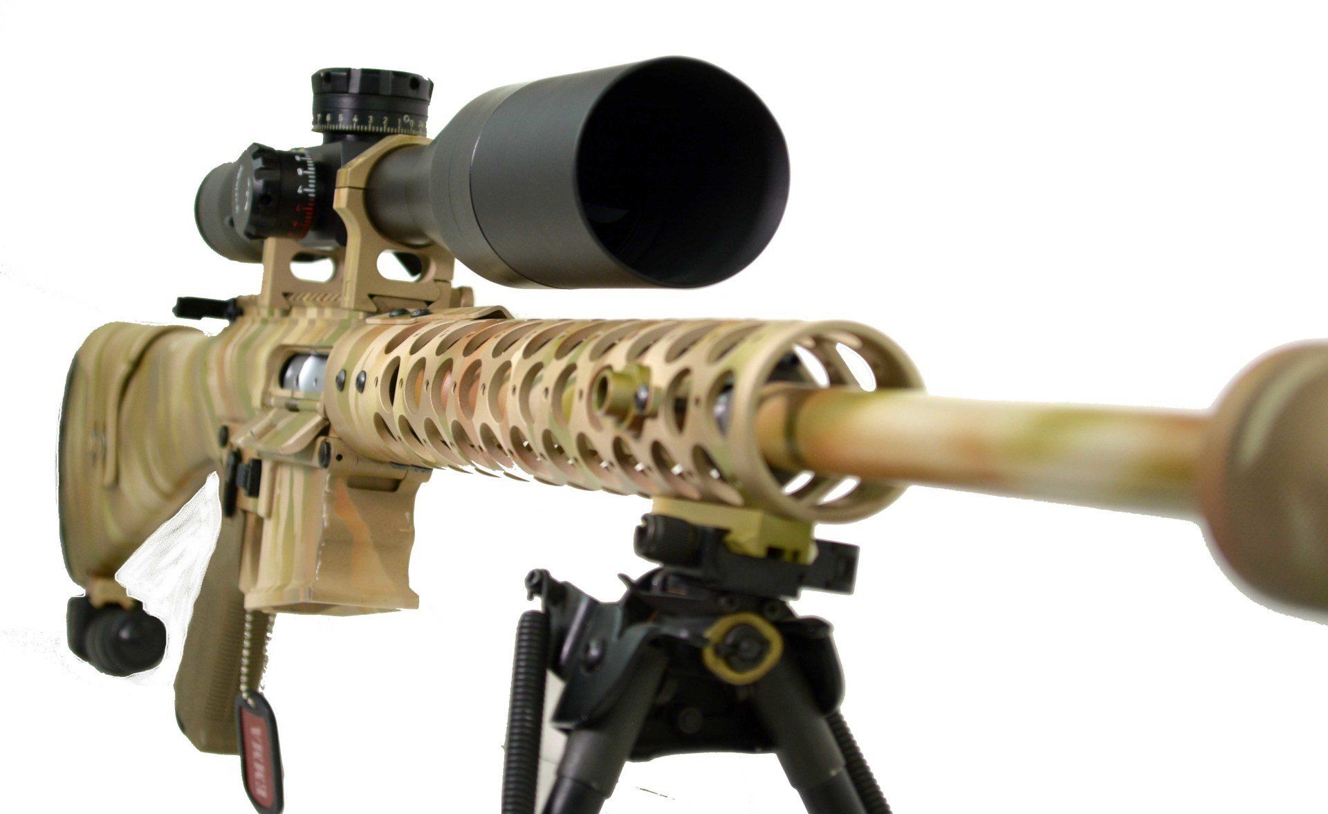 Tan and camo sniper rifle with large scope, mounted on a bipod, against a white background.