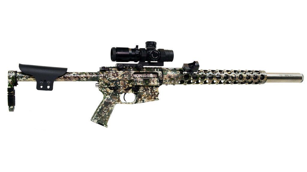 Camouflage-patterned rifle with a scope attached, against a white background.