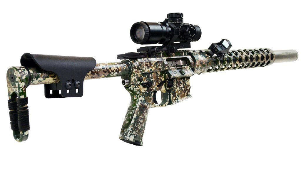 Camouflaged rifle with scope and stock against white background.