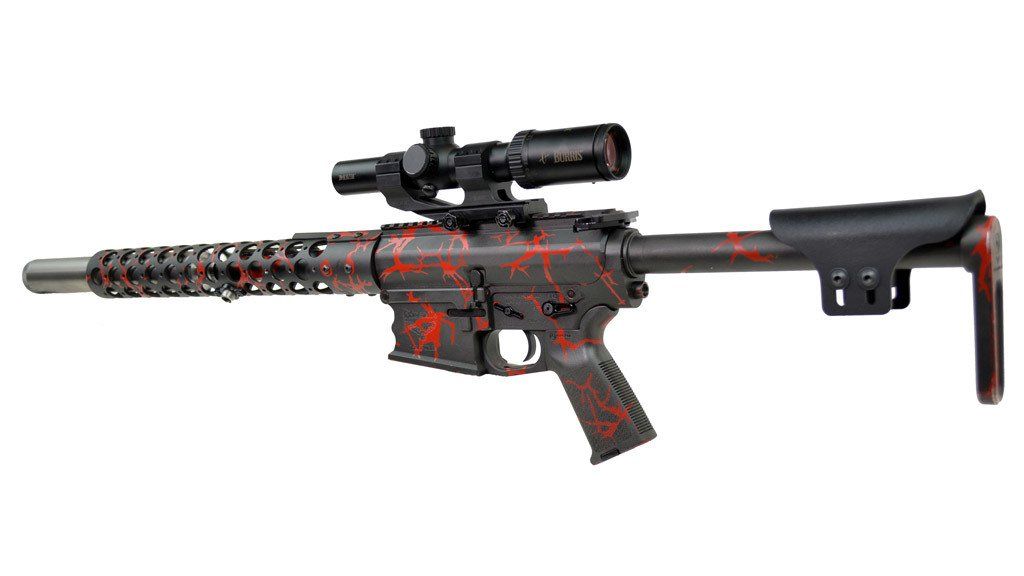 Red and black camouflage rifle with a scope, against a white background.